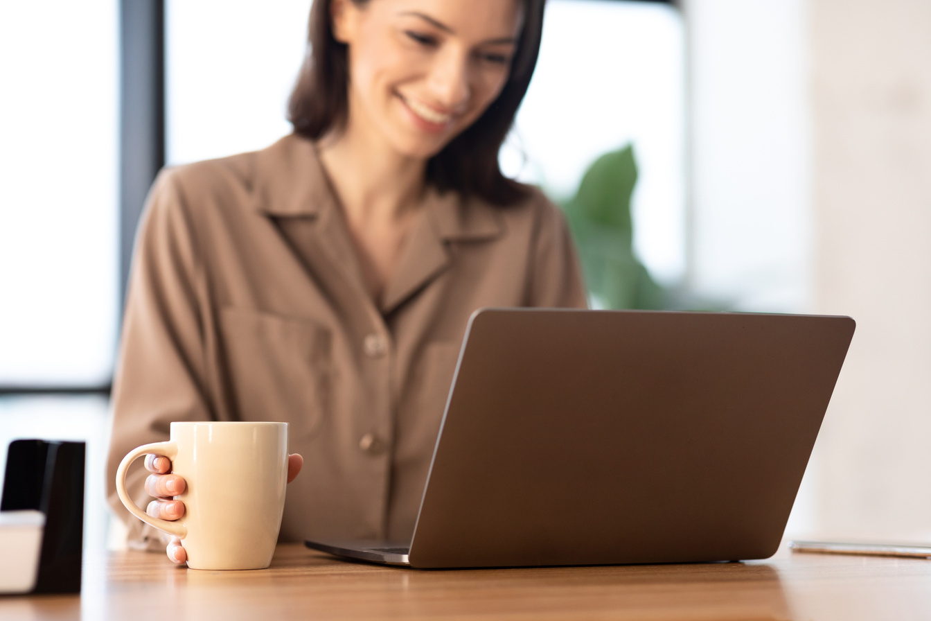 Smiling woman working on personal computer at cafe